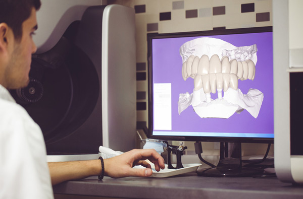 Man sitting at desk looking at a digital dental impression from Roy C. Blake III, DDS, MSD, Maxillofacial Prosthodontist in West Palm Beach, FL
