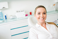 A smiling female patient in the dental chair at the office of Roy C. Blake III, DDS, MSD, Maxillofacial Prosthodontist in West Palm Beach Florida.